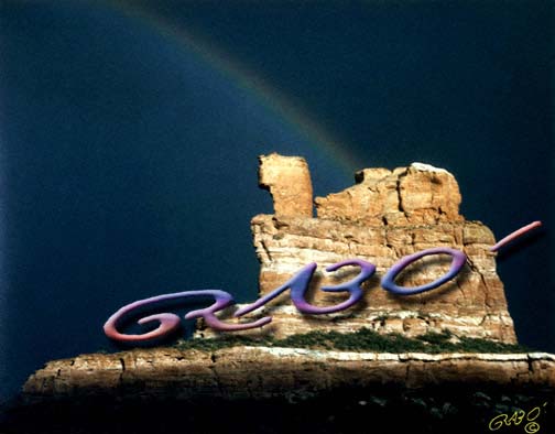 Colorado pictures:  How fortunate I was to live a half-mile up the road when this happened!  I love the way the sky changes colors on either side of the rainbow, and the way Camel Rock (Chimney Rock) contrasts with the dark sky.  For less than it would cost to frame this Colorado picture at most local framing shops, you can have it , photograph and all!  (Colorado photography / Colorado geological formations / rainbow pictures)